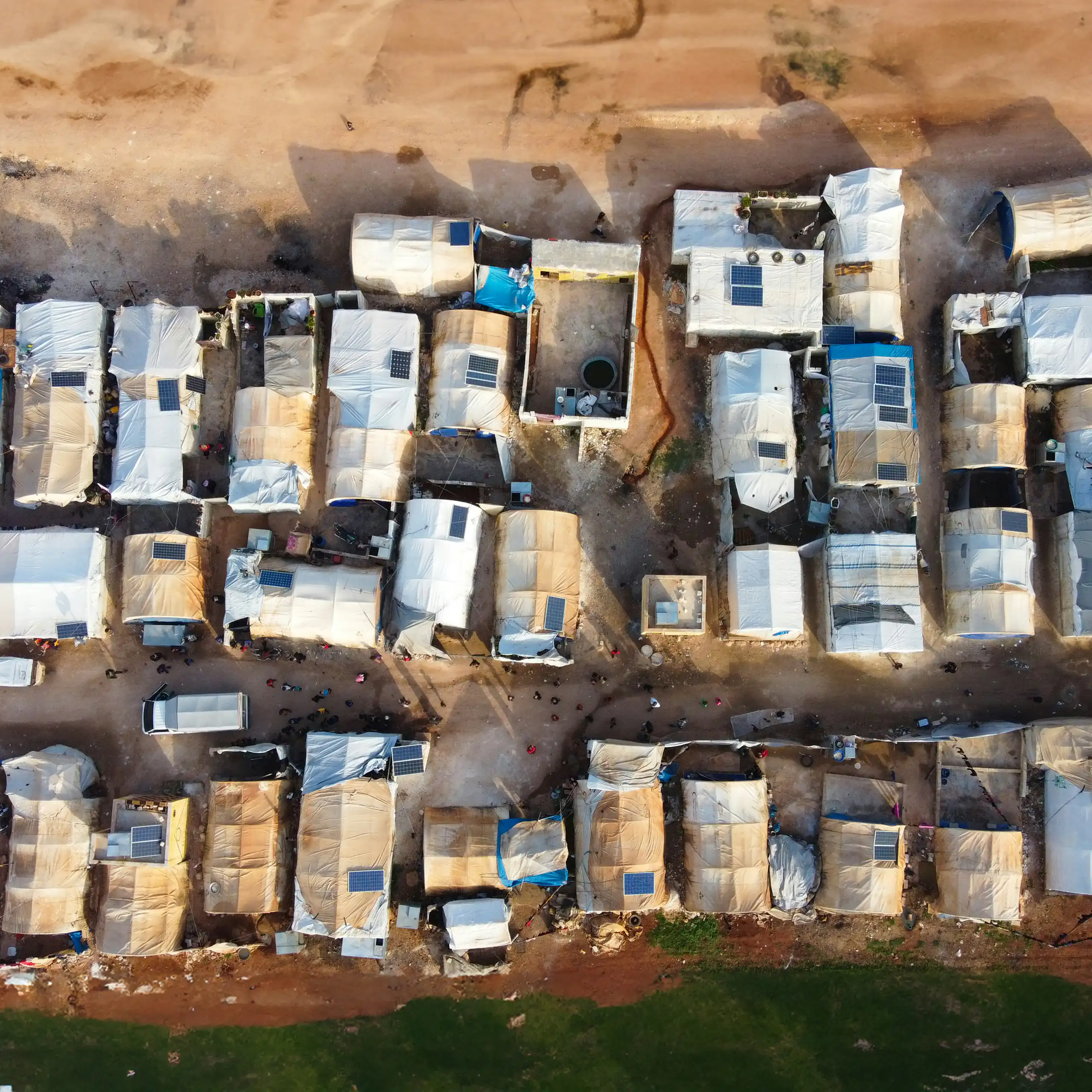 A topshot of makeshift housing on dusty ground