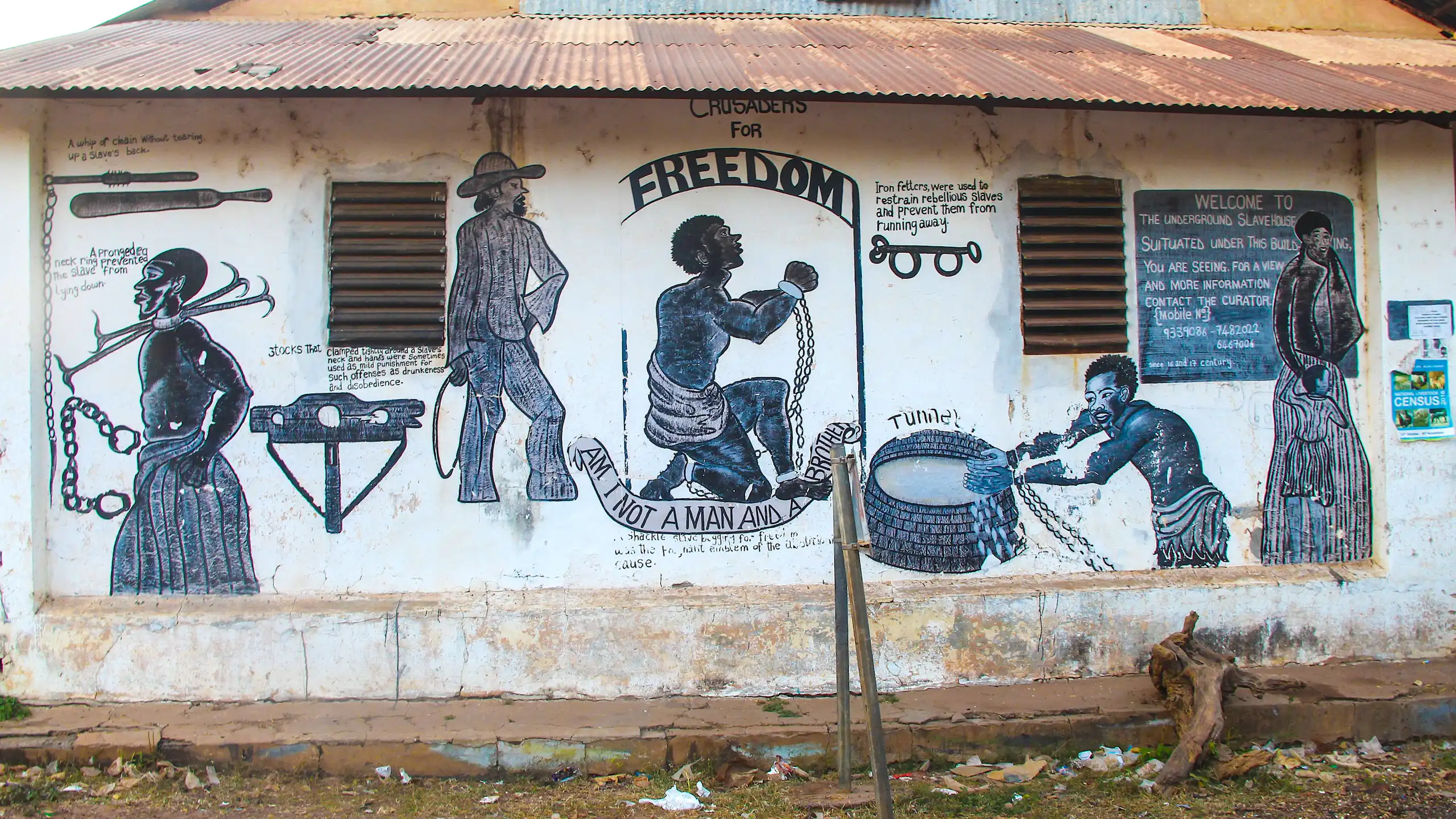 A mural shows depictions of enslaved people in shackles and colonial masters in western clothing.