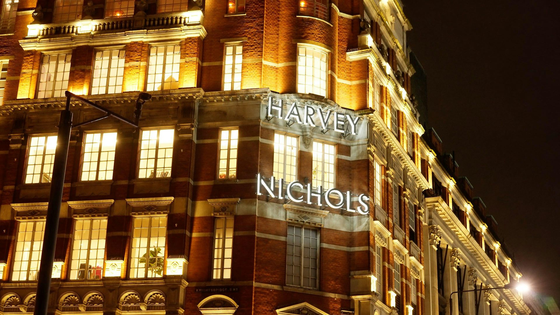 The front of a Victorian red brick and cream facade department store building in London.