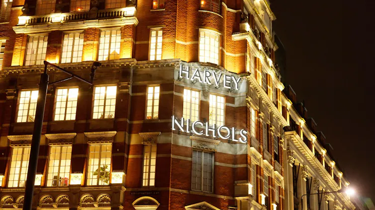 The front of a Victorian red brick and cream facade department store building in London.