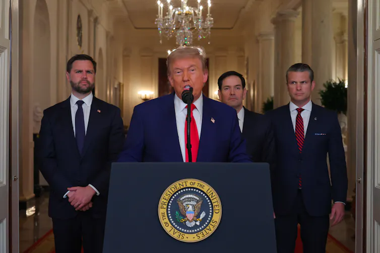 Donald Trump at a podium in the White House. Behind him are secretary of war Pete Hegseth, vice-president JD Vance and secretary of state Marco Rubio.