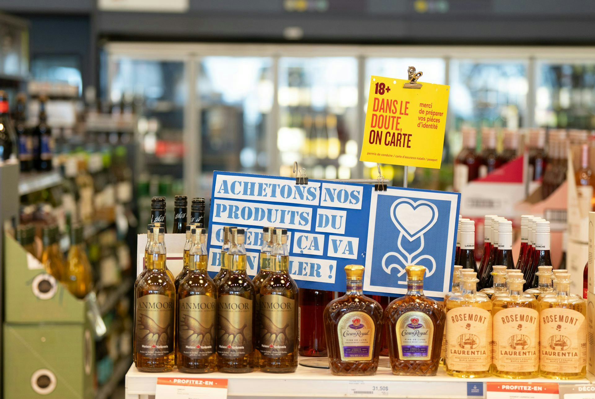 Des bouteilles d'alcool sur une tablette avec des affiches au-dessus