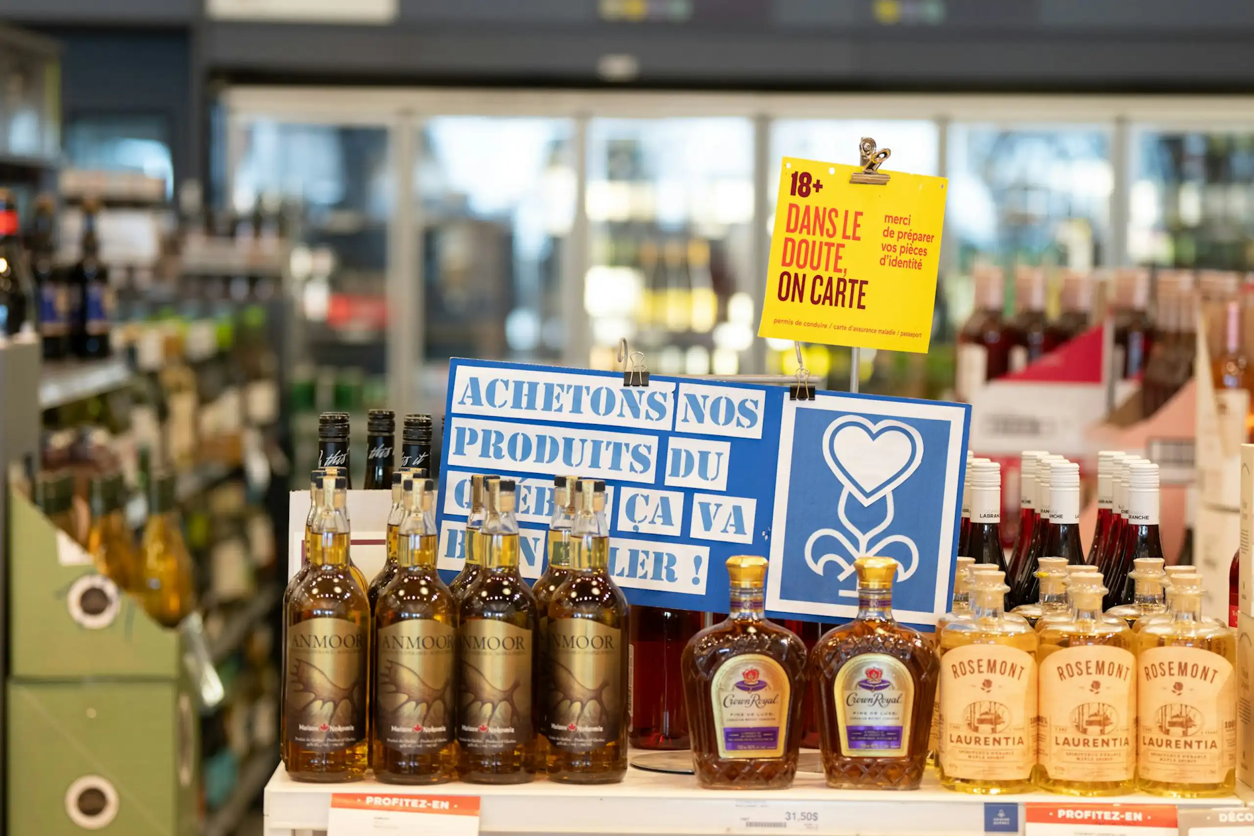 Des bouteilles d'alcool sur une tablette avec des affiches au-dessus