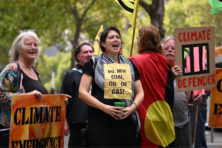 A woman at a climate protest holding a reusable cup