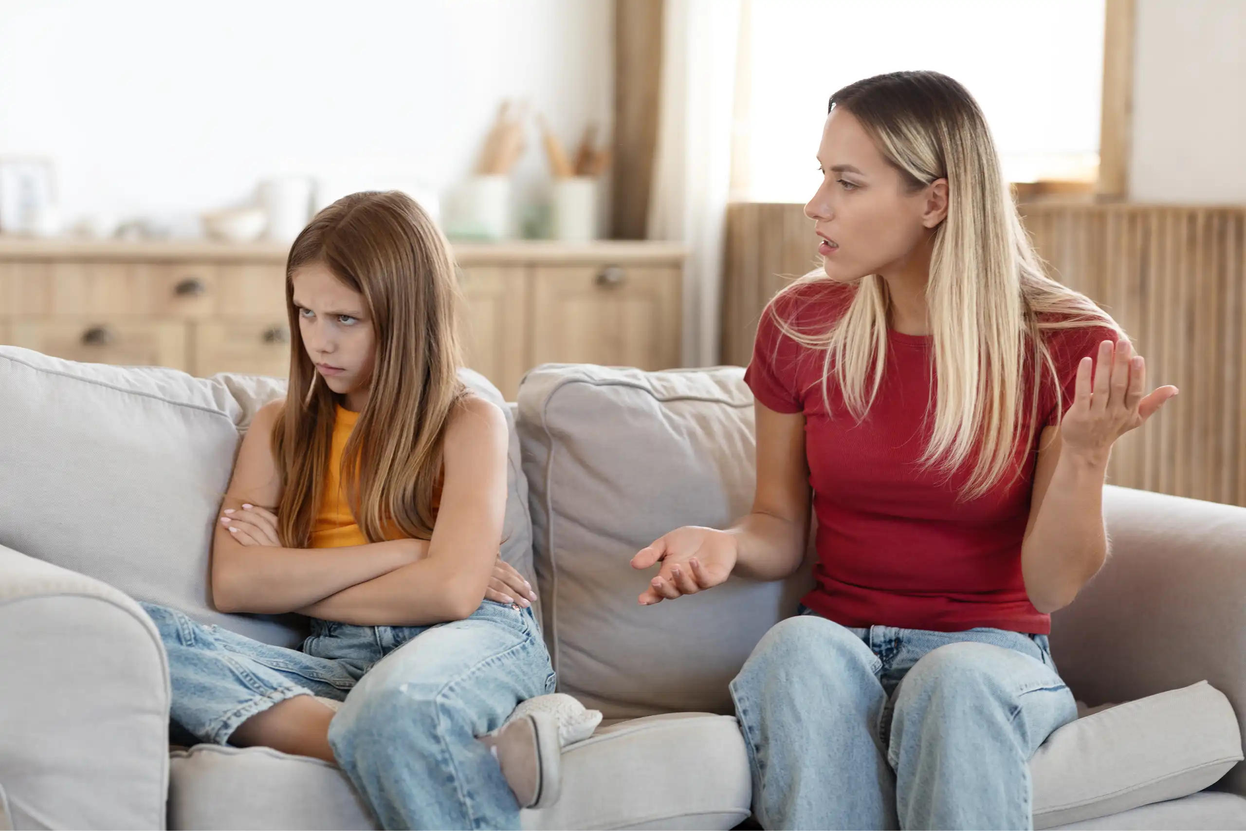 Una mujer habla a una niña con gesto de enfado