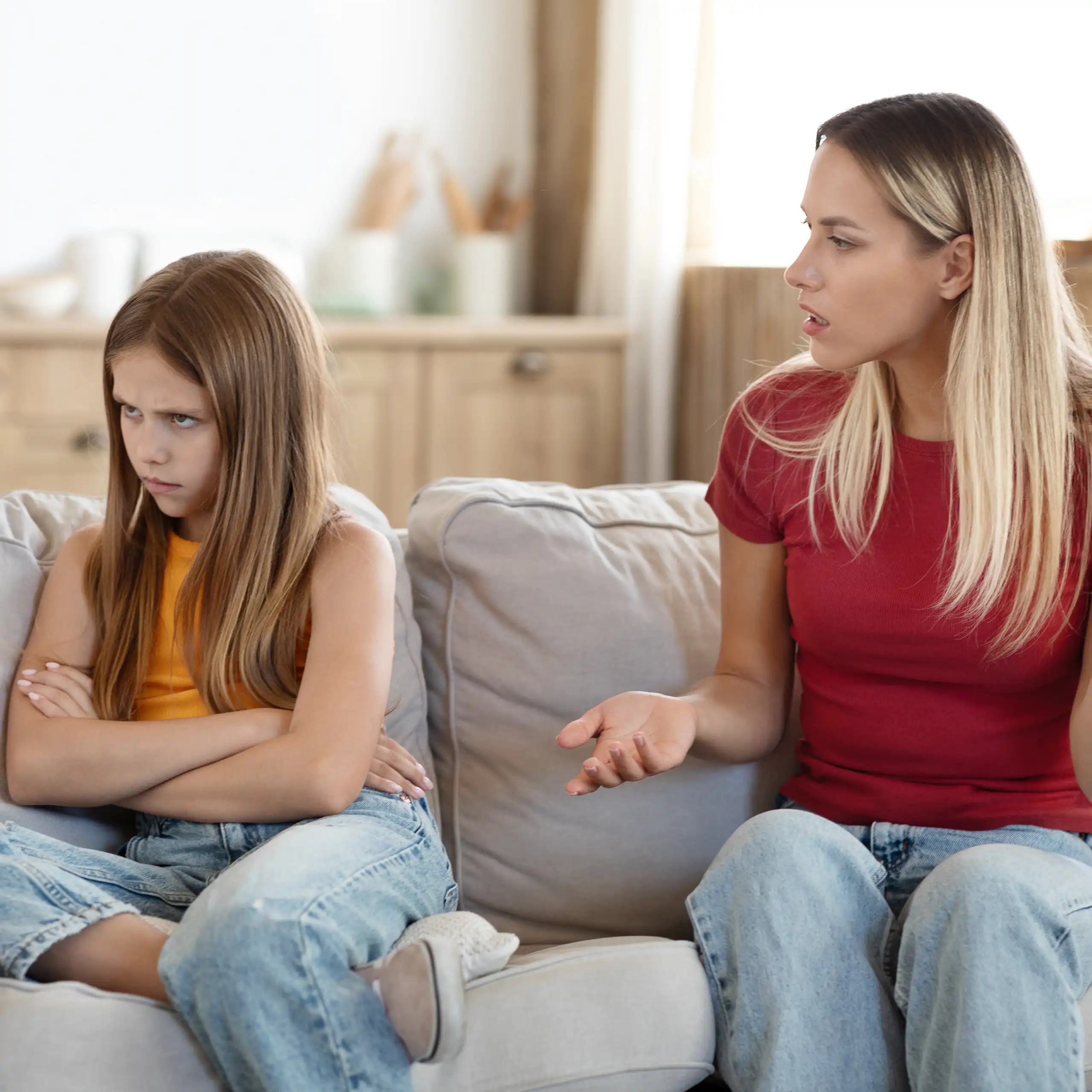 Una mujer habla a una niña con gesto de enfado