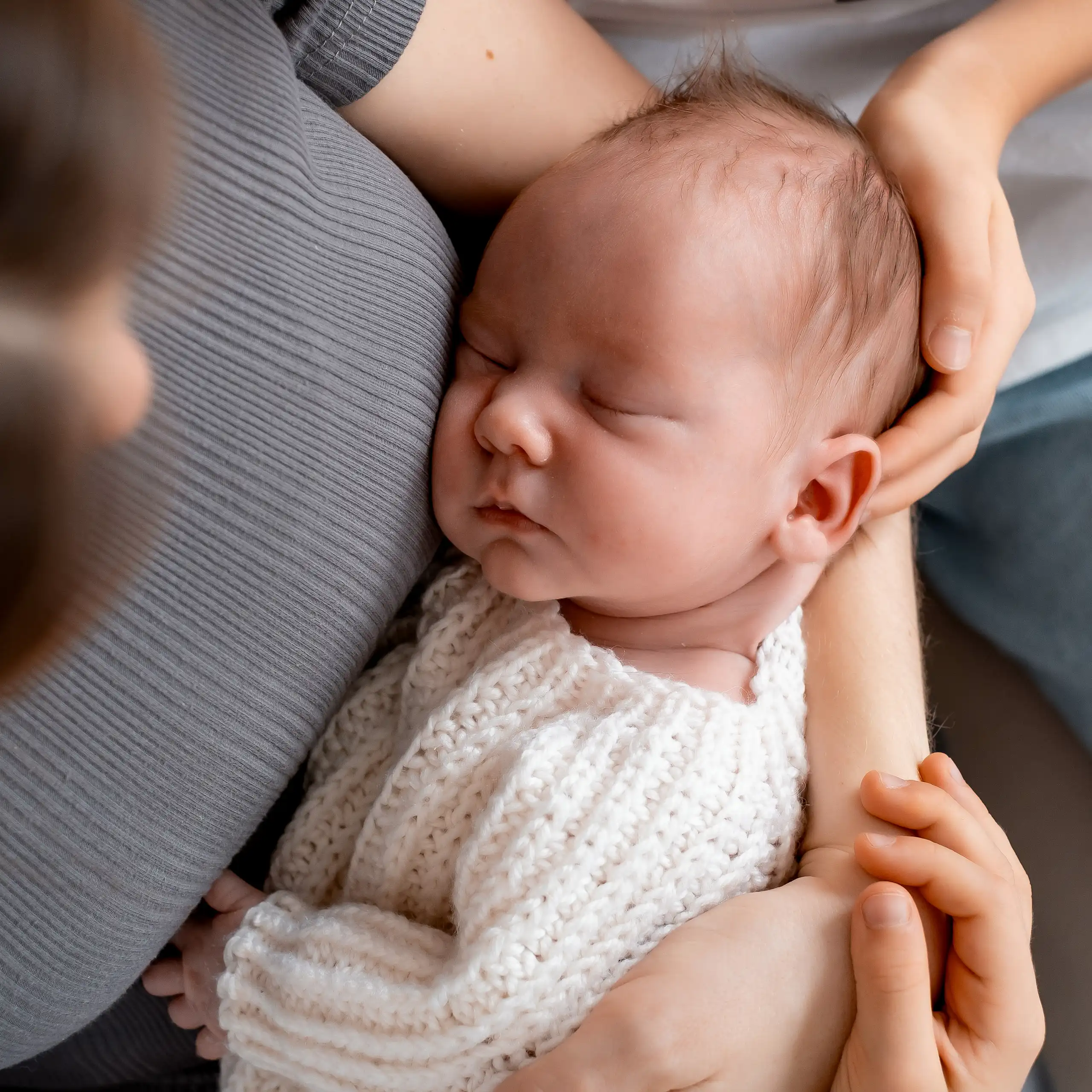 View from above of a newborn sleeping in mother's arms