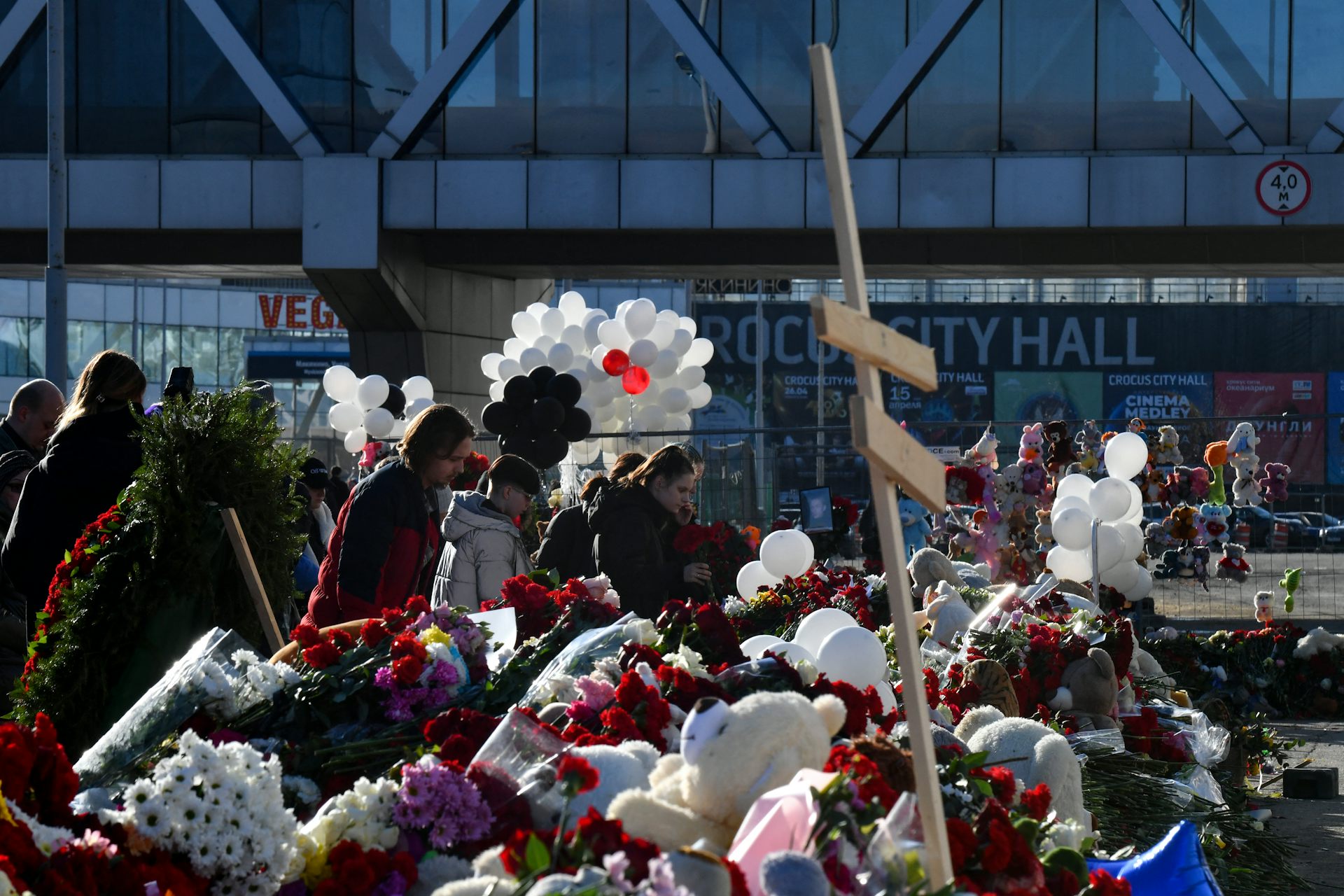 Flowers, balloons and teddy bears are scattered around a makeshift memorial