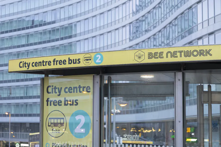 bus stop with yellow sign saying city centre free bus, bee network