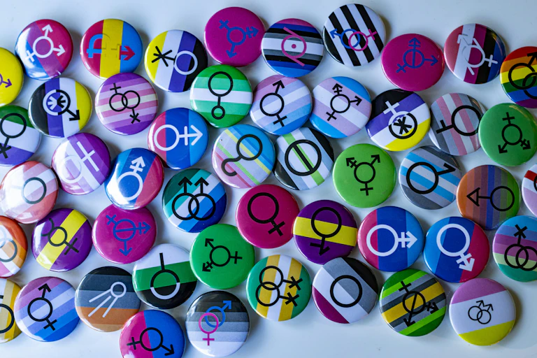 A collection of pins with different symbols of gender diversity on each.