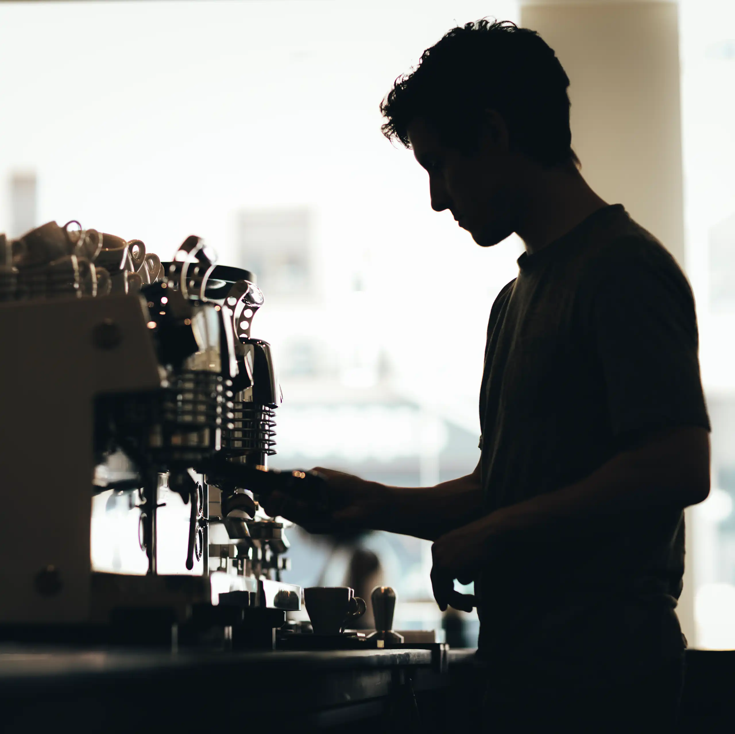Silhouette of a barista preparing coffee