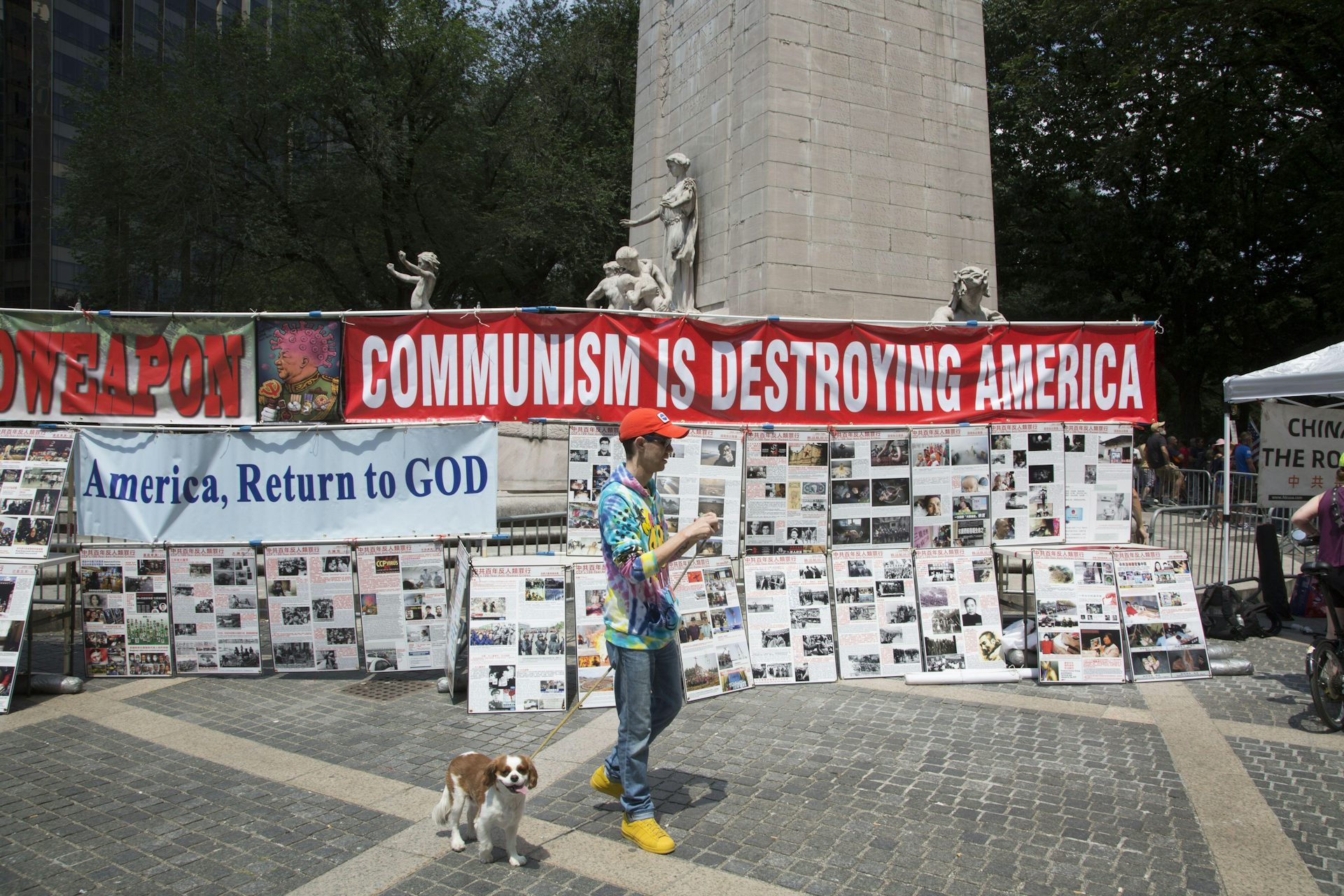 A man and his dog walk past a display of anti-communist propaganda.