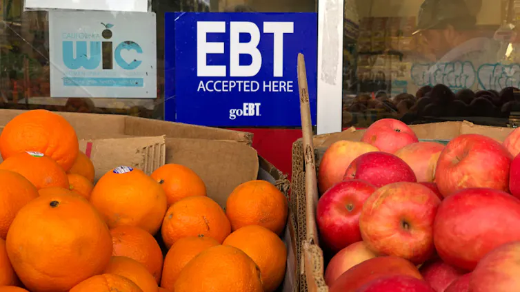 A blue sign above boxes of fruit reads SNAP