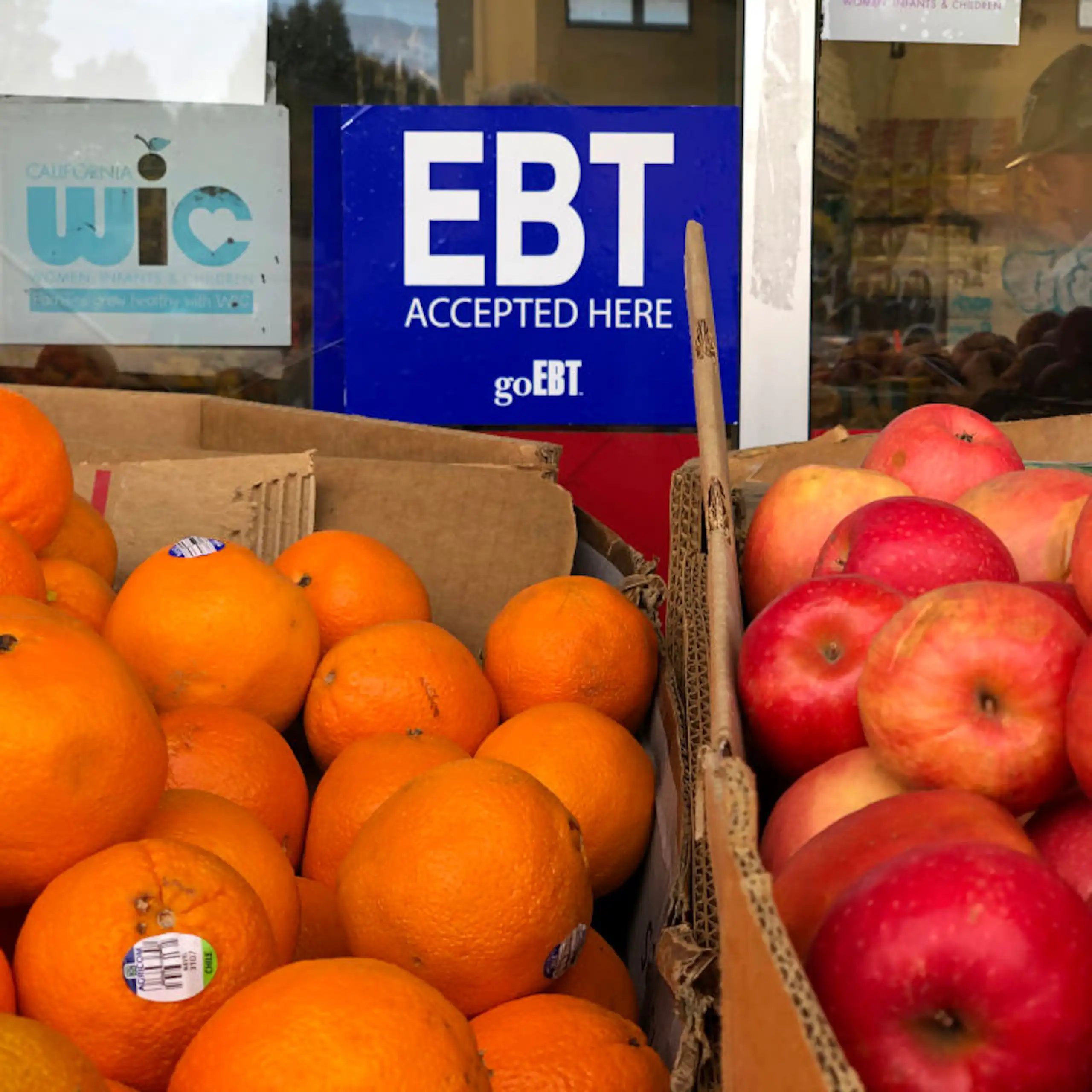 A blue sign above boxes of fruit reads "EBT accepted here."