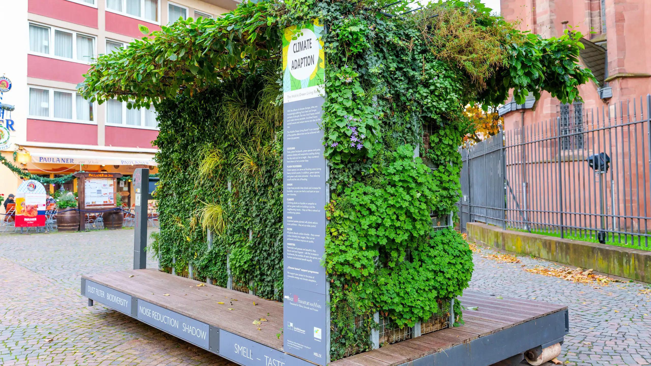 Pan de mur végétalisé en exposition sur une place publique poue en expliquer les avantages.