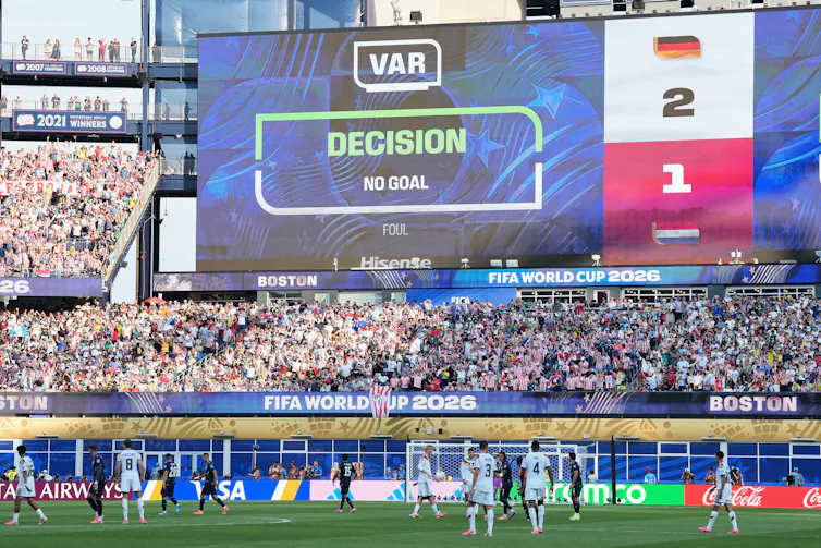 a large video display board in a crowded stadium