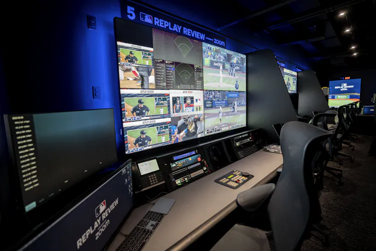 a dark room with several large video displays showing multiple images