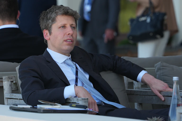 A man sits in shirt and tie gazing into the distance.