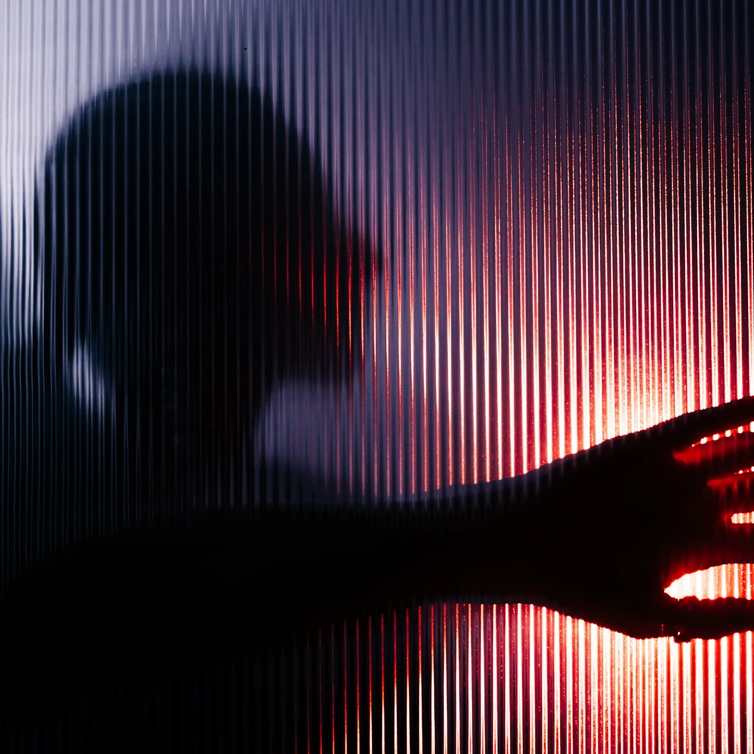 Blurred figure with raised hand seen through opaque glass