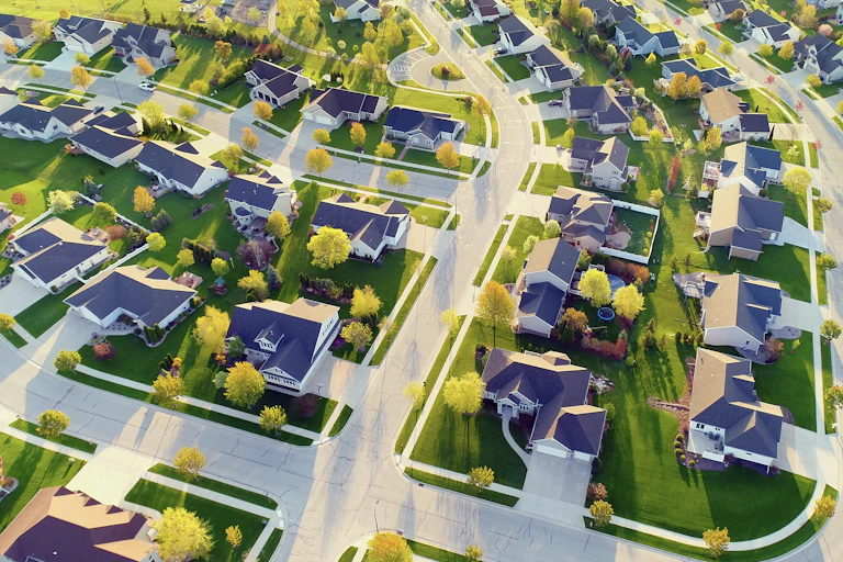 A neighborhood of homes, all with very similar green lawns.