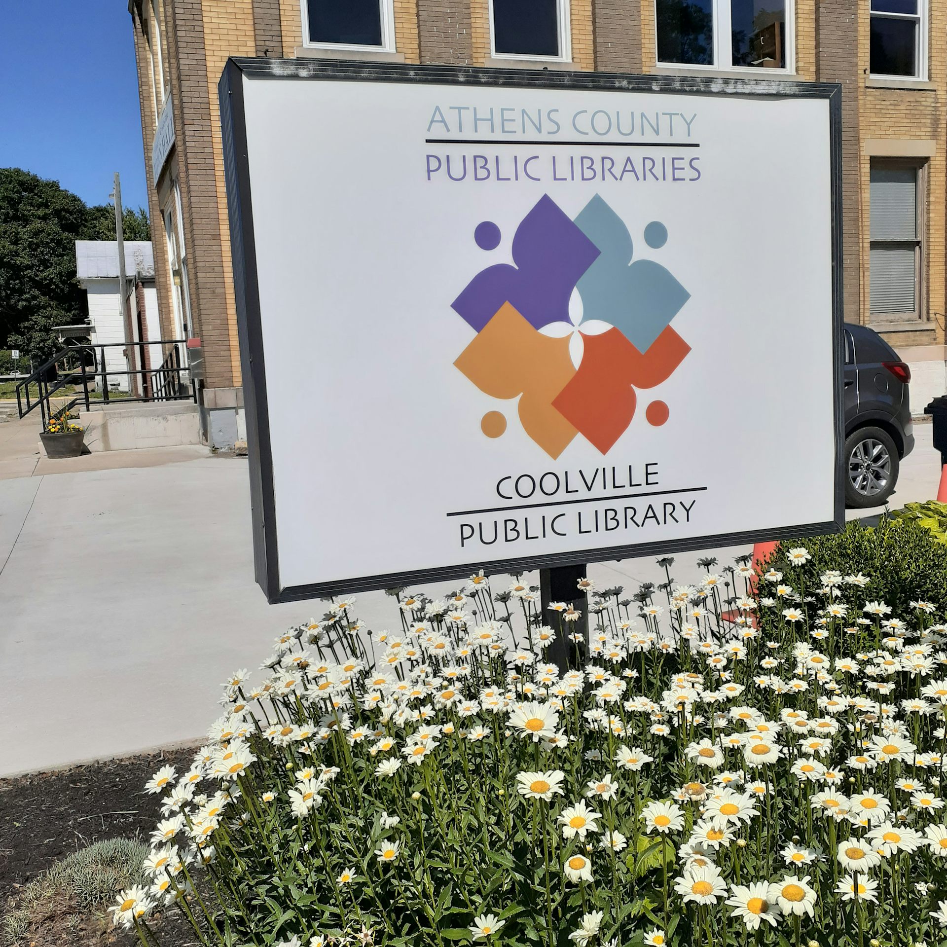 A library sign reading 'Coolville Public Library'