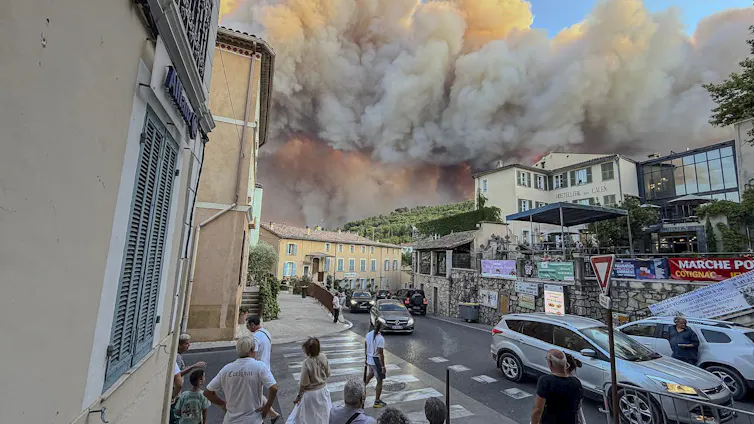people in town watching smoke and fire threatening them.