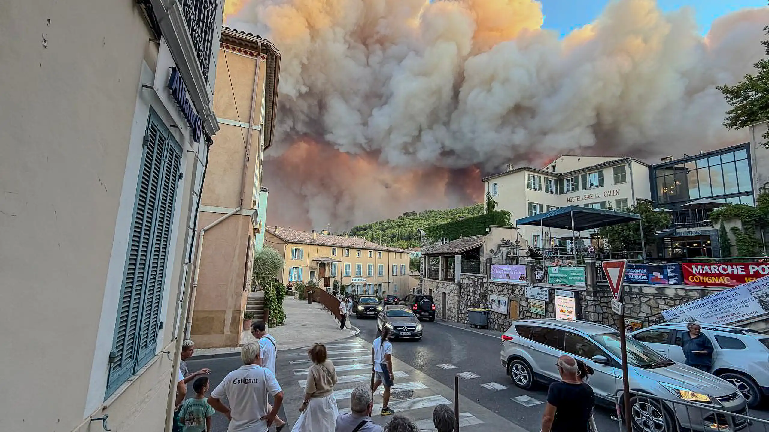 people in town watching smoke and fire threatening them.