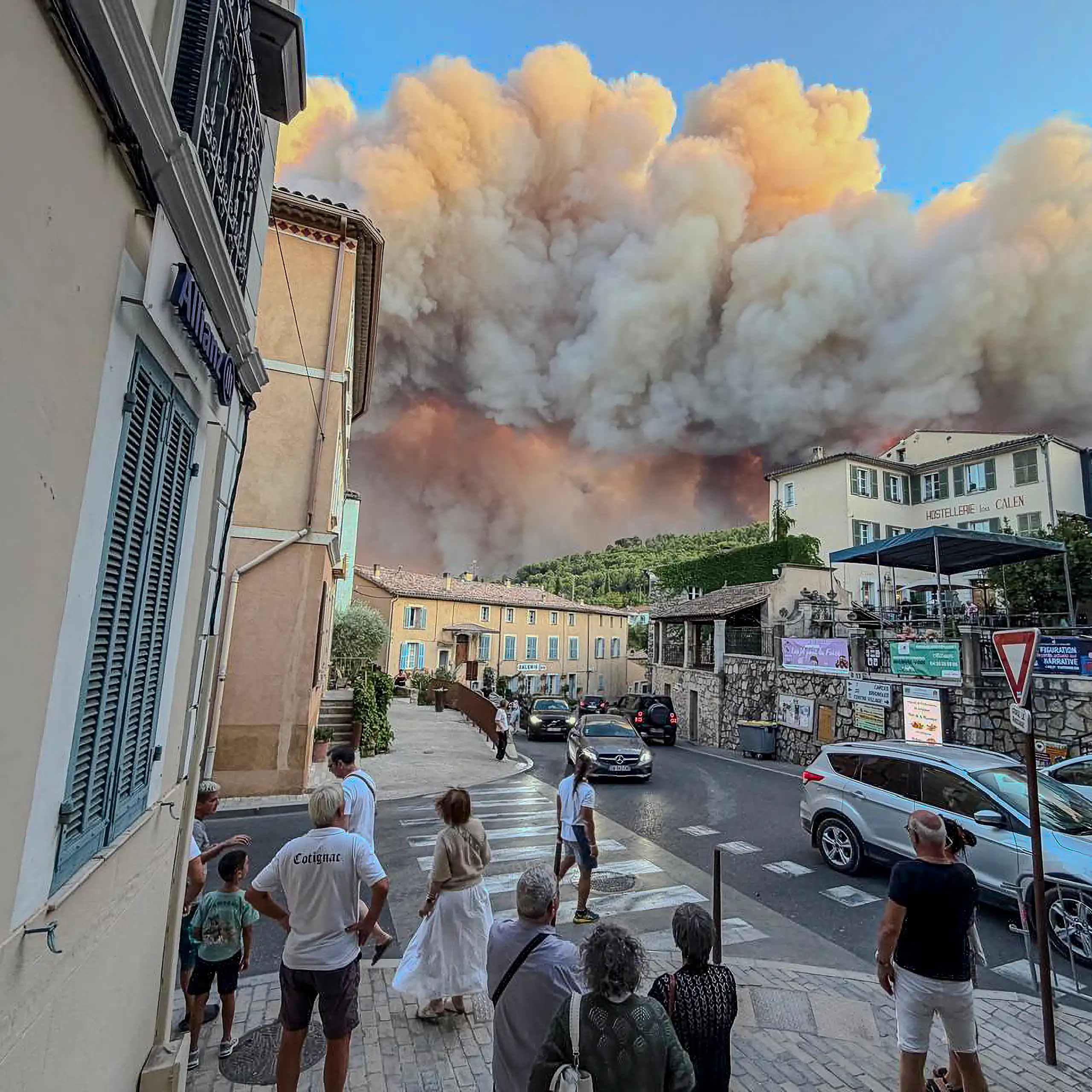 people in town watching smoke and fire threatening them.