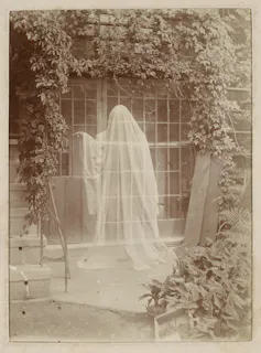 A sepia photograph showing a classic ghost-in-a-sheet figure