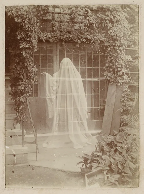 A sepia photograph showing a classic ghost-in-a-sheet figure