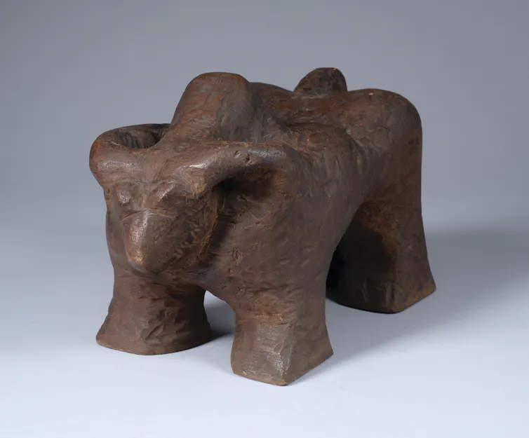 An abstract wooden sculpture of a buffalo