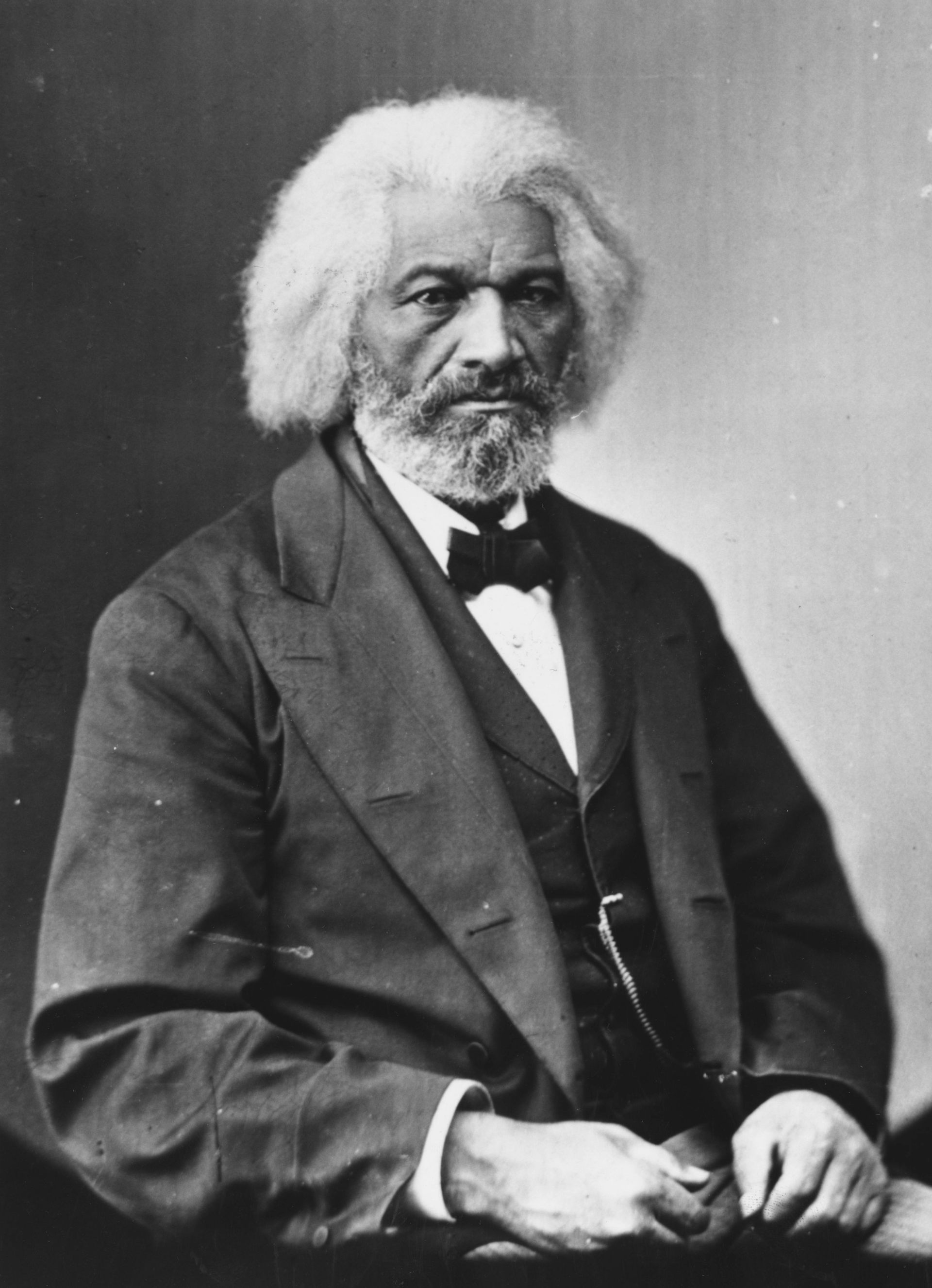 A black-and-white image of a man in a suit and bow tie