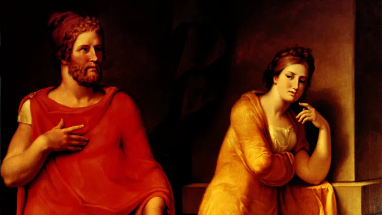 a man in a red robe and woman looking a bit bored in gold robe