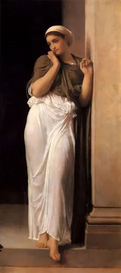 a young woman in a white sheet skirt, head wrapped in cloth