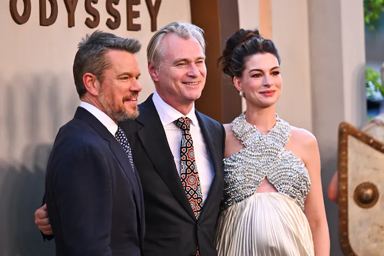 two men in suits and a woman in evening dress