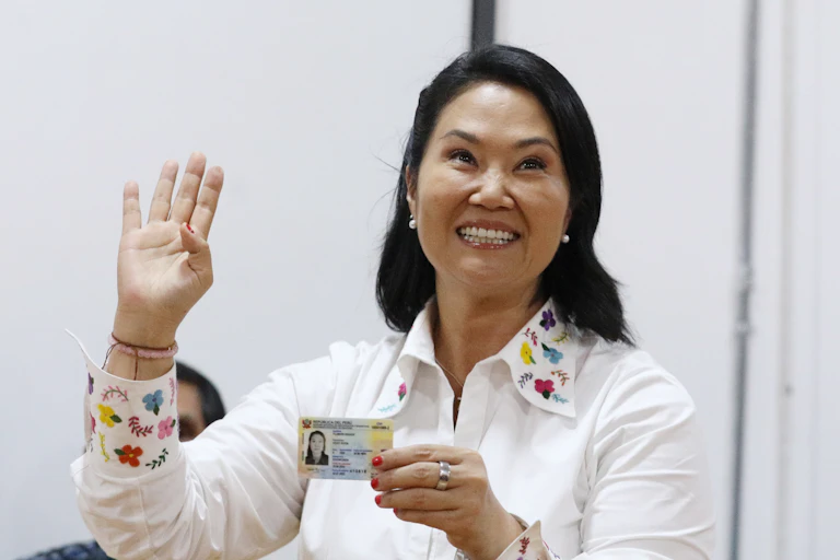 Una mujer sonriente con su documento de identidad en la mano.