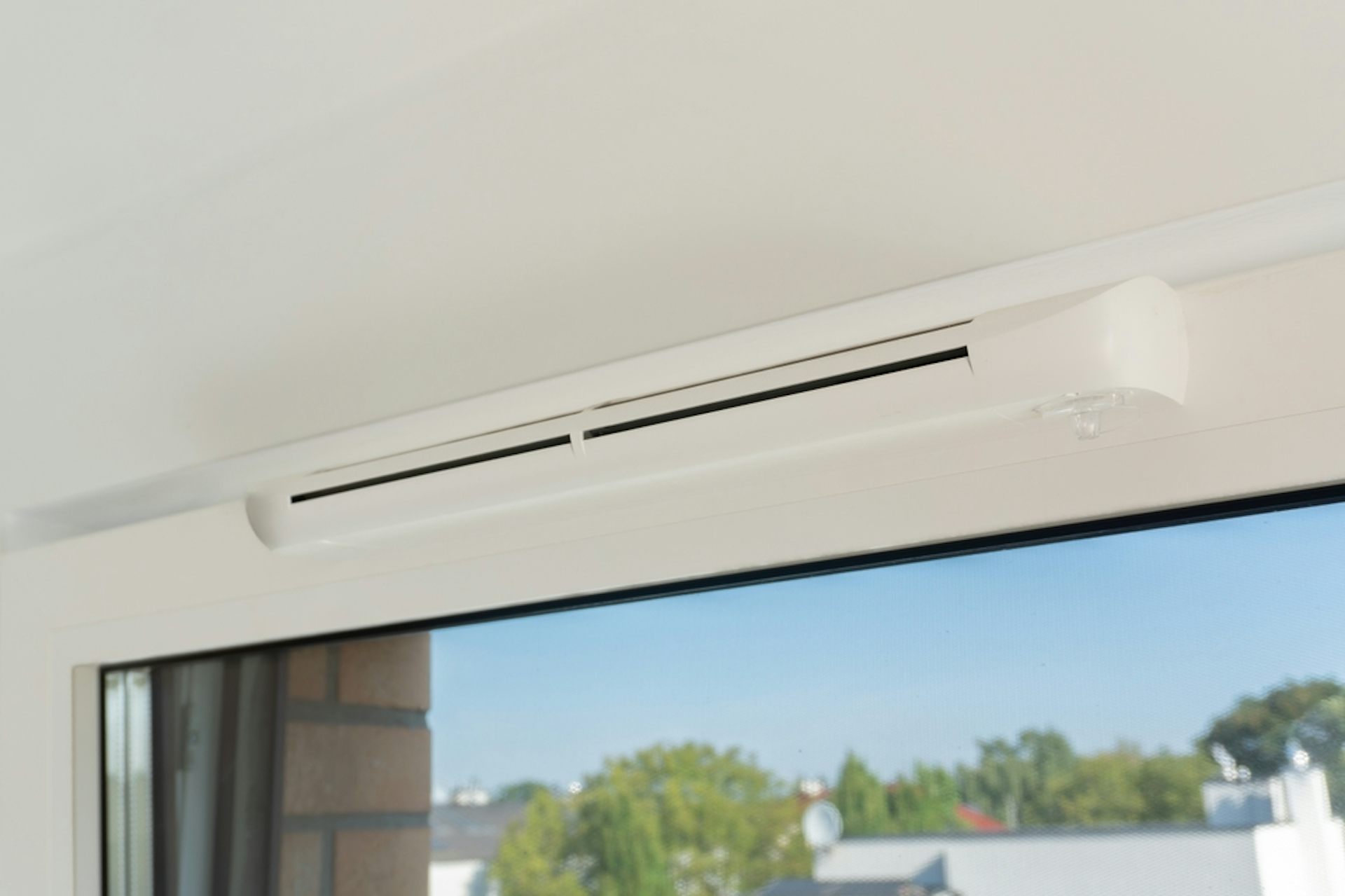 A trickle vent above a window.