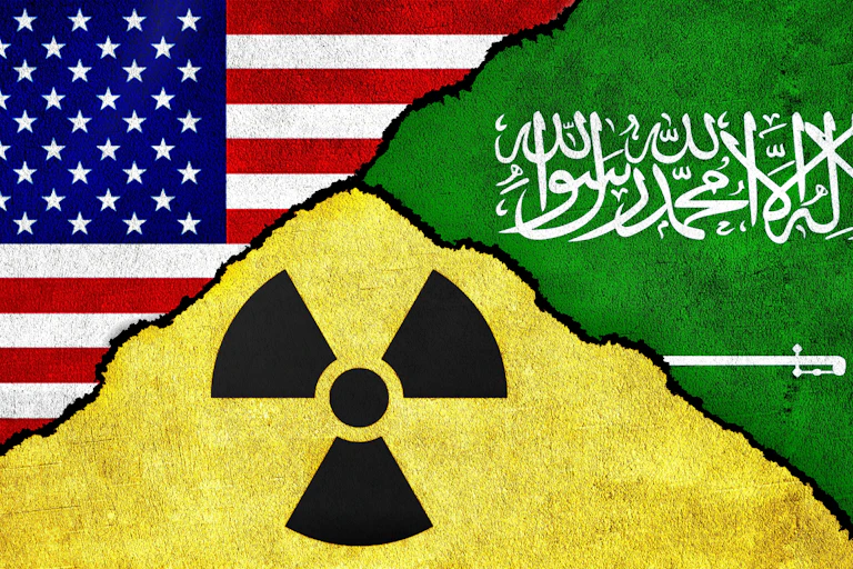 Flags of the United States and Saudi Arabia, together with a nuclear symbol, on a textured wall