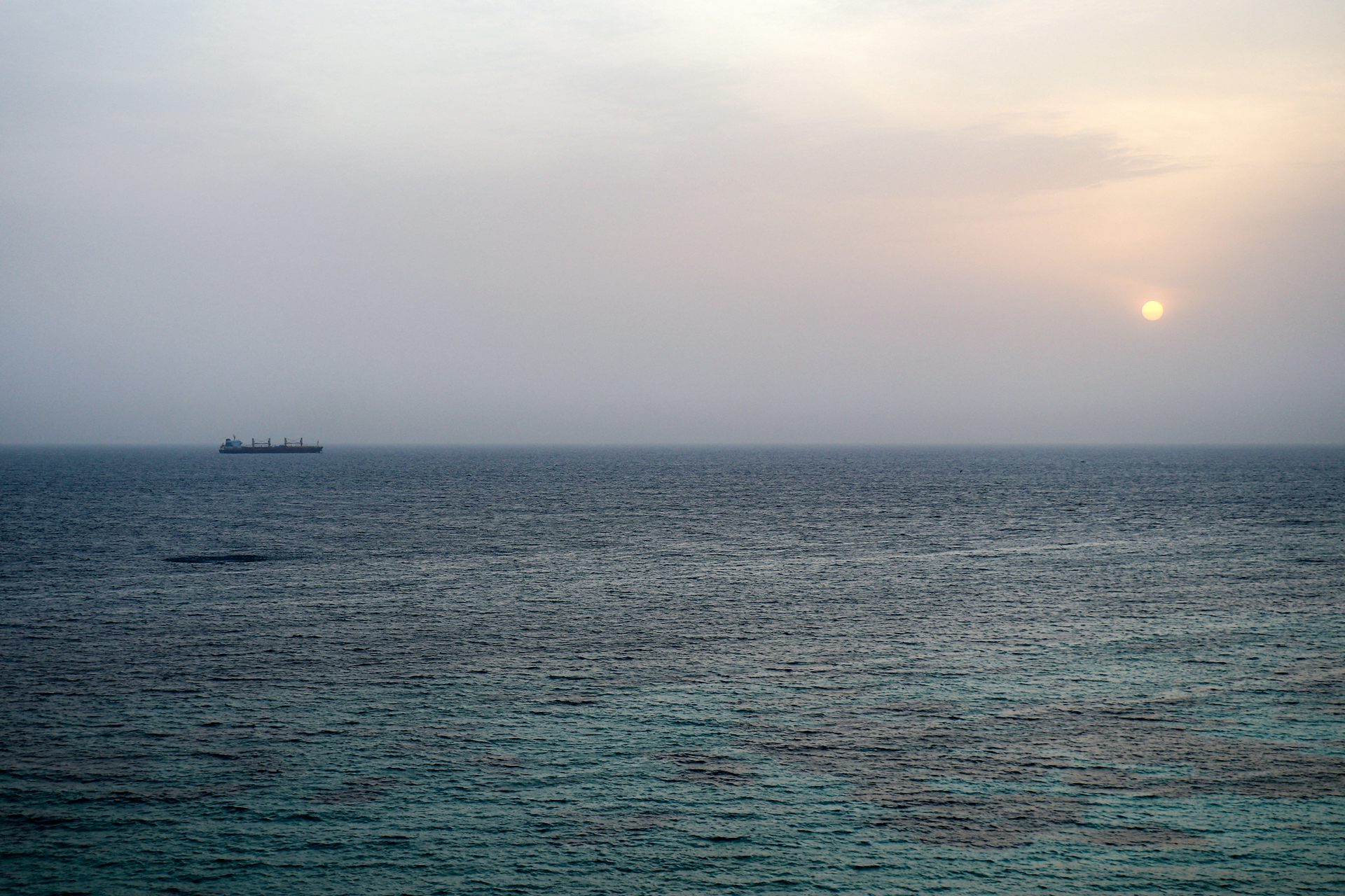 A commercial vessel sails in a body of water.