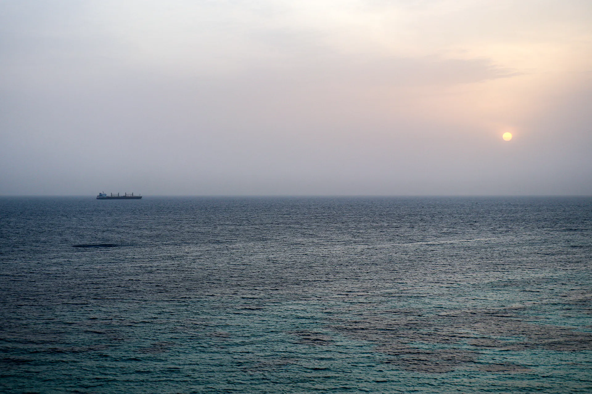A commercial vessel sails in a body of water.