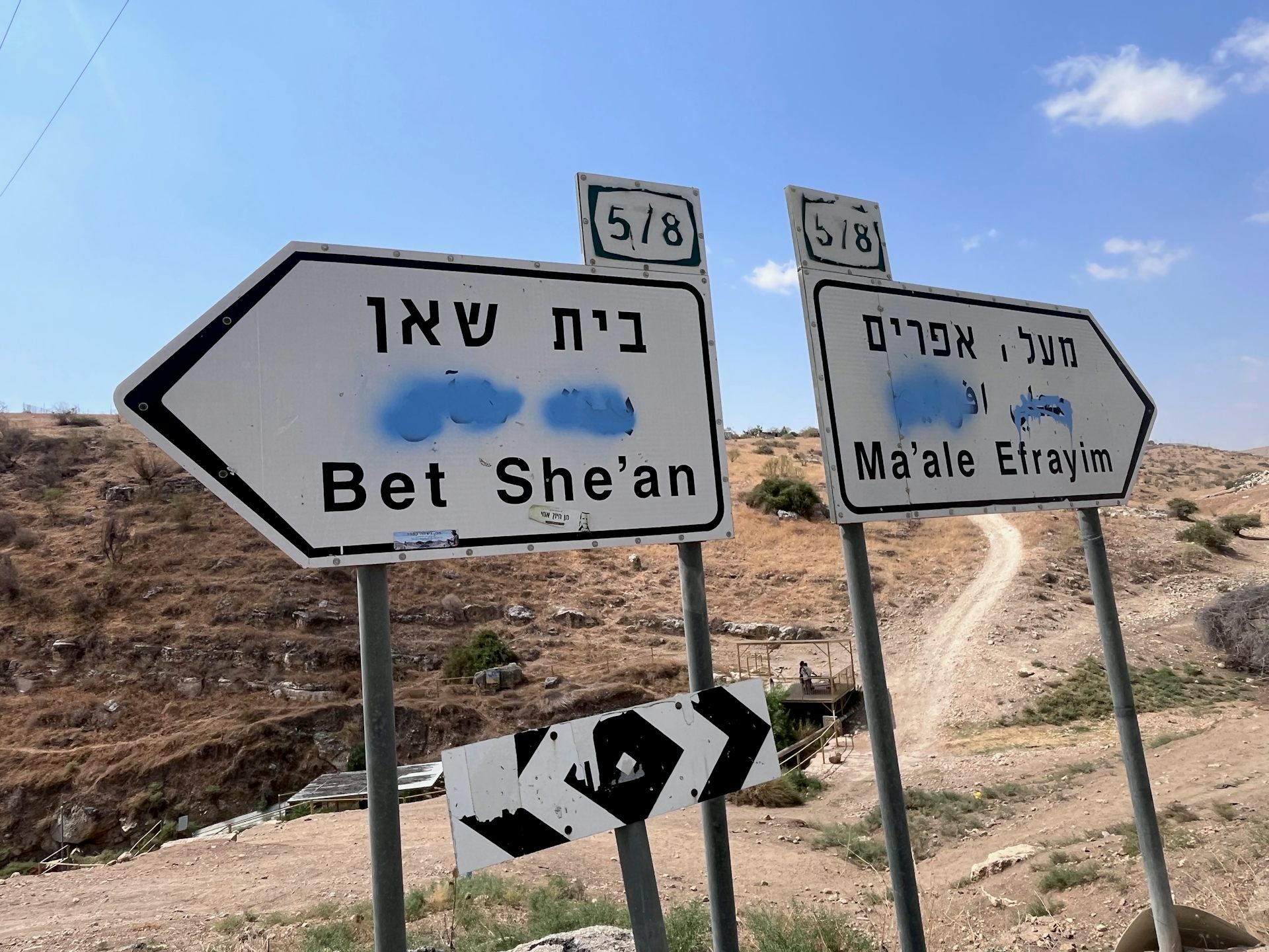 road signs with Arabic writing painted over