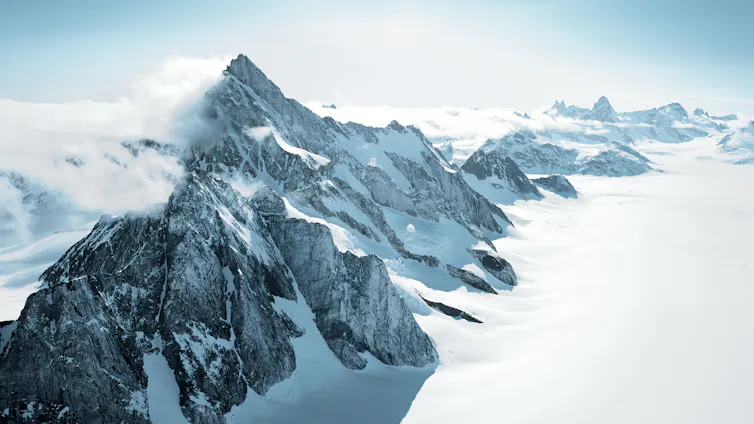 A mountain range peeking out of ice and snow