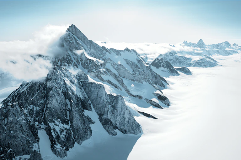 A mountain range peeking out of ice and snow