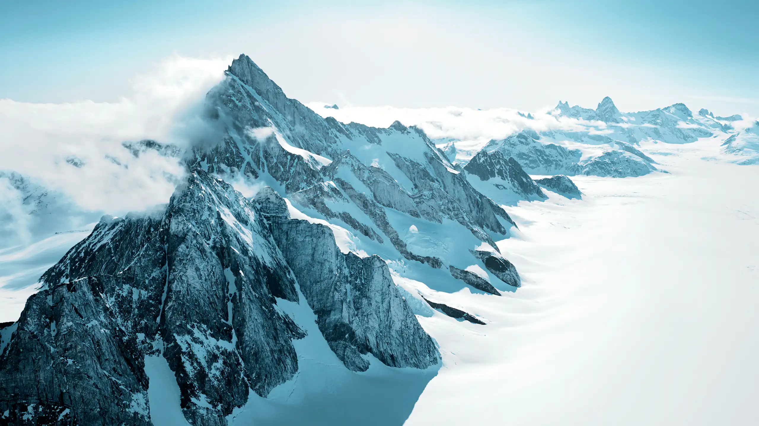 A mountain range peeking out of ice and snow
