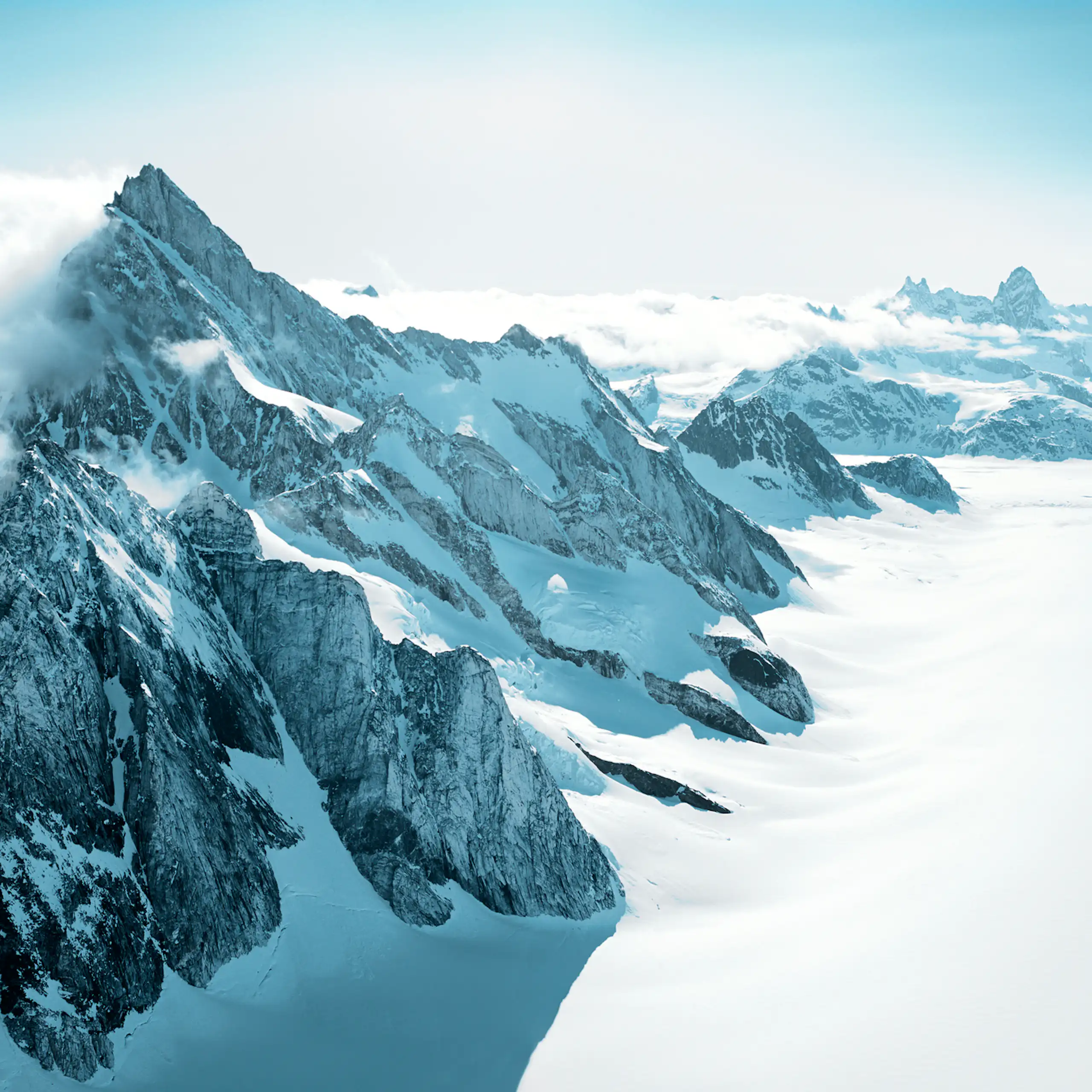 A mountain range peeking out of ice and snow
