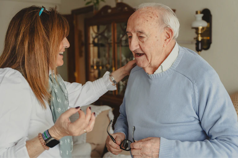 A woman talks to her ageing dad at home