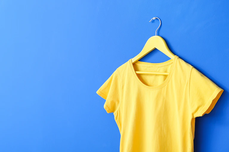 yellow T-shirt on hanger, blue background