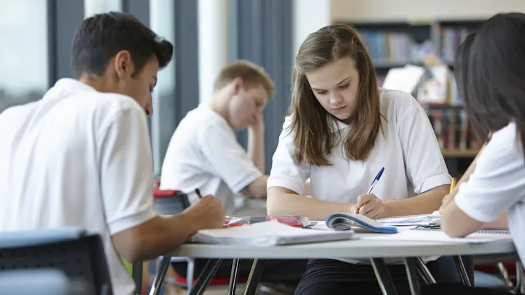 Group of teenagers working in school class.