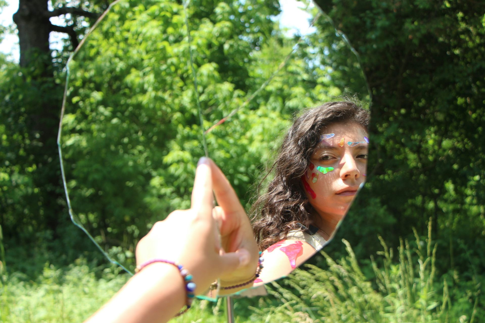 A woman's face is seen reflected in a mirror.
