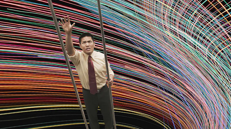 A businessman is unable to reach next rung on a a ladder against a swirling backdrop.